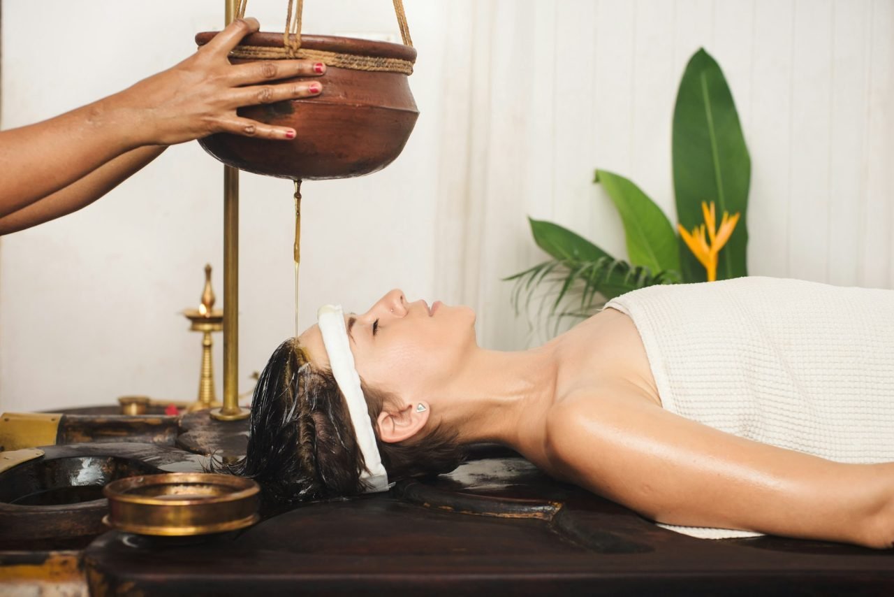caucasian woman having ayurveda shirodhara treatment in india.jpg